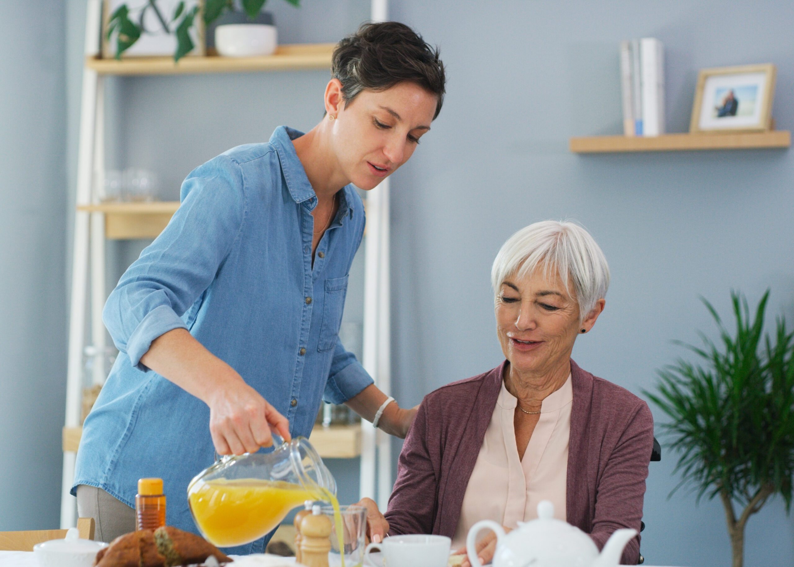 Elderly woman smiling while a caregiver assists her at home, symbolizing quality home care services in Philadelphia that enhance senior well-being.